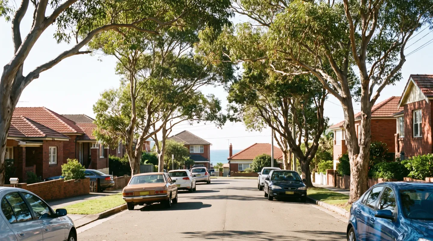 A leafy Newcastle residential street of brick-and-tile homes with a glimpse of the ocean